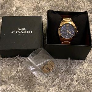 Coach watch in gold with blue face.